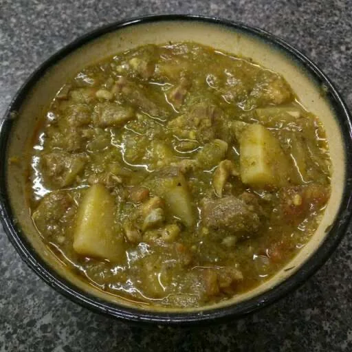 A bowl of green chile stew with pork and potatoes.