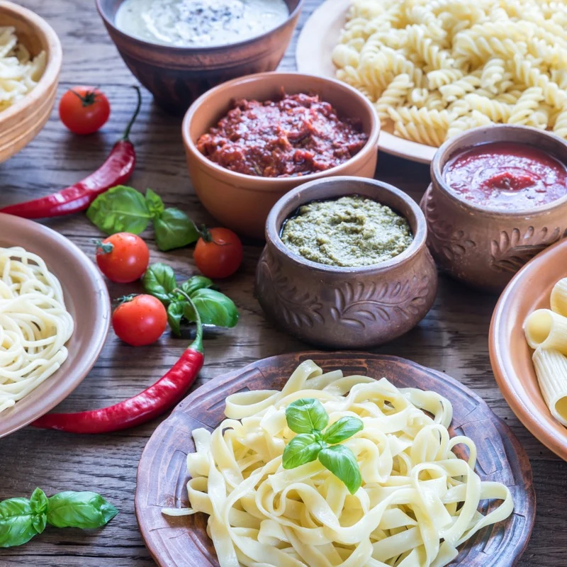 Fresh pasta with several sauces, tomatoes and basil.