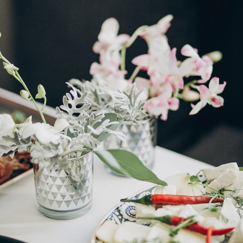 Cheese and fresh flowers arranged in a layered table display.