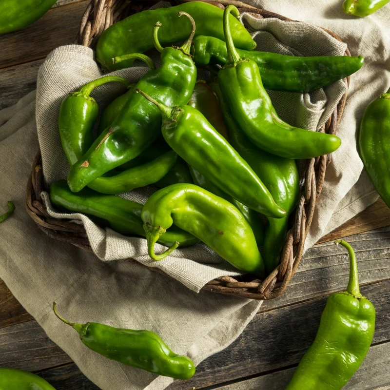 Fresh green Hatch chile in a woven basket.