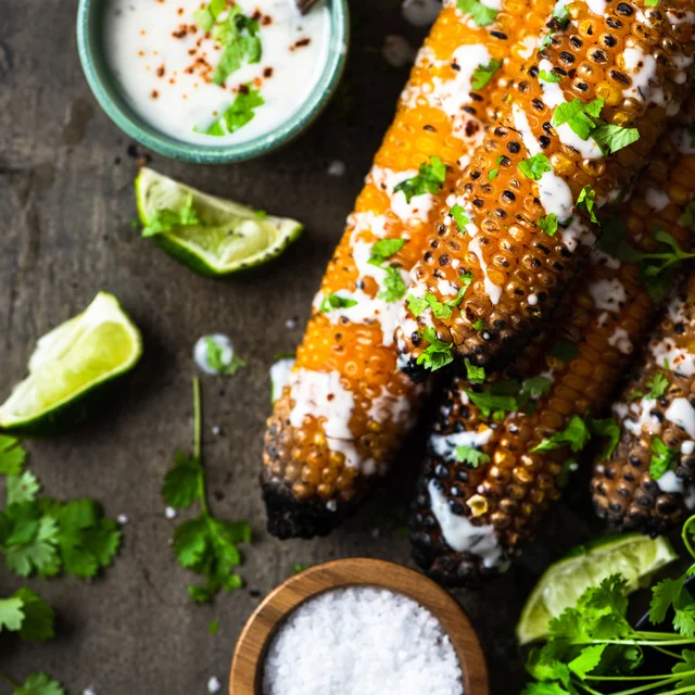 Grilled corn with creamy topping, herbs and lime.
